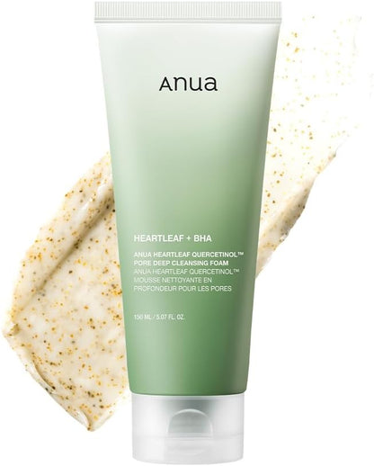 Green tube of Anua facial cleanser with a beige scrub in the background